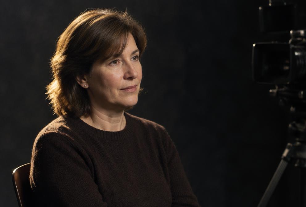Woman seated for a filmed studio interview